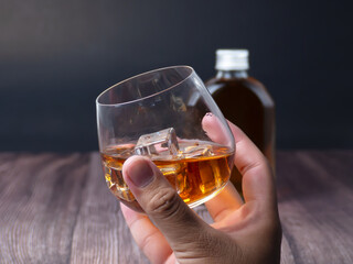 hand holding a glass of whiskey