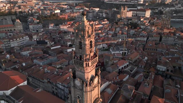 Aerial orbiting shot of historic landmark Clerigos Tower (Portuguese: Torre dos Clerigos) at sunset in Porto (Oporto), Portugal. 