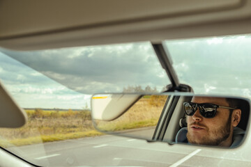 man reflection in car rear mirror