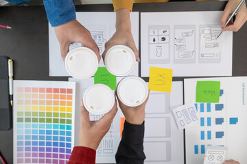 Programmers and UI ux designers have cup of hot coffee together in design studio during breaks for...