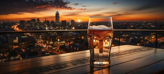 Fotobehang Beer on a table in a restaurant overlooking the city and the sunset.  © André
