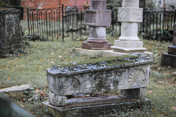 Fototapeta na wymiar Ancient cemetery gravestone covered with moss