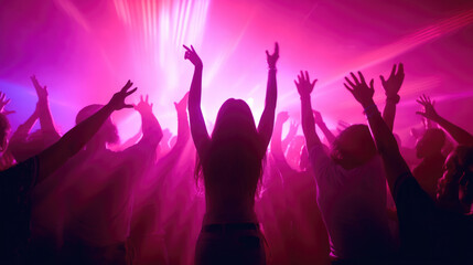 Fototapeta na wymiar Team. A crowd of people in silhouette raises their hands on the dancefloor on neon light background. Night life, club, music, dance, motion, youth. Purple-pink colors and moving girls and boys.