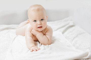 Concept lotion for skin of infant. Portrait happy little baby boy after applying body cream