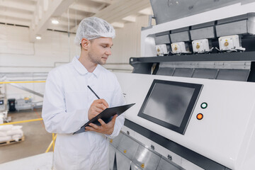 Operator man checks control panel food products conveyor with wheat flour. Modern electrical mill...
