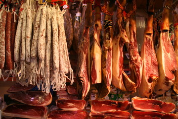 A display of various cuts and types of meat suspended on hooks, tantalizingly awaiting customers’...