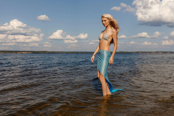 a girl in a mermaid dress on the riverbank, taken on a sunny day