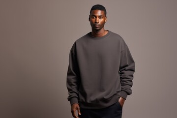 Obraz premium Isolated Portrait of a Fictional Male Model Wearing a Large Oversized Charcoal Colored Sweatshirt on a Plain Blank Background. Generative AI.