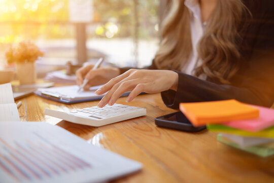 An accountant is using a calculator to accurately calculate the income and expenses and is using the calculator to review the company investment results and profits Copy Space for text