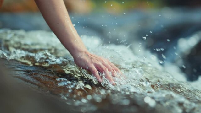 B roll - Close up hand of traveler woman touching water in the forest from waterfall, Slow motion, Tourist travel enjoying nature and life concept. Go everywhere.