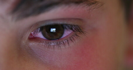 Boy eye staring at tablet screen playing video-game on tech, macro closeup eyes