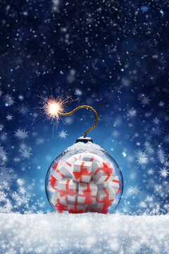 Christmas card with a Christmas ball and a gift inside in the form of a bomb on the snow. Festive banner with hoarfrost on night abstract defocused lights background.