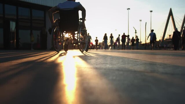 A man in a wheelchair riding in the sports park at sunst