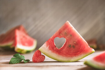 A cut piece of watermelon with a heart-shaped hole. Summer, joy, happiness, delicious food