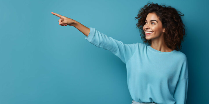 woman pointing finger on blue background with copy space, fashion, business