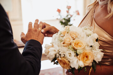 Obraz na płótnie Canvas bride and groom holding hands rings