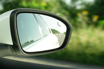 Rear view mirror, close-up, with reflection of a white car when the car is moving. An essential element for driving safety.
