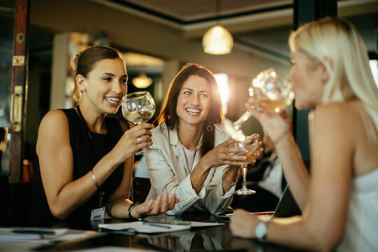Diverse group of female business friends having a glass of wine after work in a bar