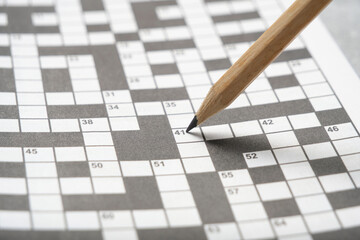Simple pencil on background crossword puzzle sheet.