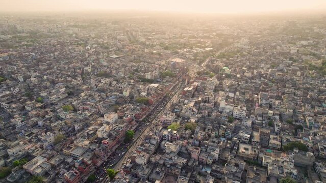 An Aerial shot of a congested Indian Urban suburb locality with vehicles or busy traffic road transportation passing from a city street or narrow lane in daylight. Cityscape, development concept