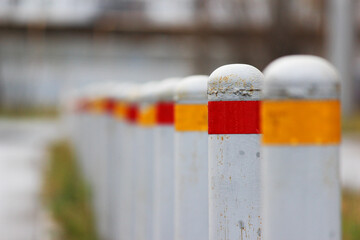 gray restrictive bollards with red and yellow stripes to limit the passage of cars. Anti-terrorist...