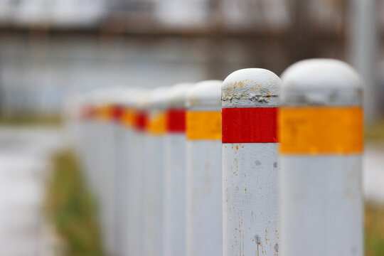 gray restrictive bollards with red and yellow stripes to limit the passage of cars. Anti-terrorist design