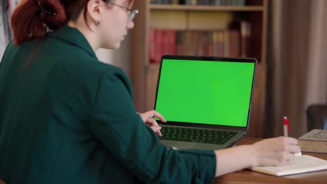 Girl Student Uses Laptop with Green Mock-up Screen to Learn in Cozy Room- Library