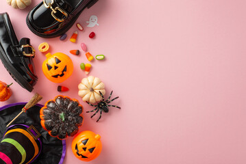 Dive into Halloween fun with this delightful costume ensemble for girls. Top view of petite leather loafers, enchanting hat, candy corn and decor on pastel pink setting. Advertise effectively here