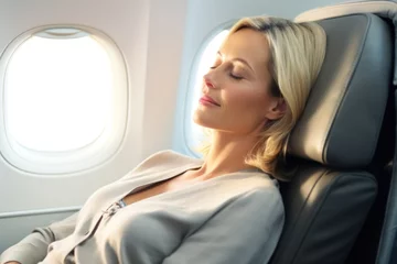 Papier Peint photo autocollant Avion Beautiful blond woman sitting sleeping in airplane business class seat
