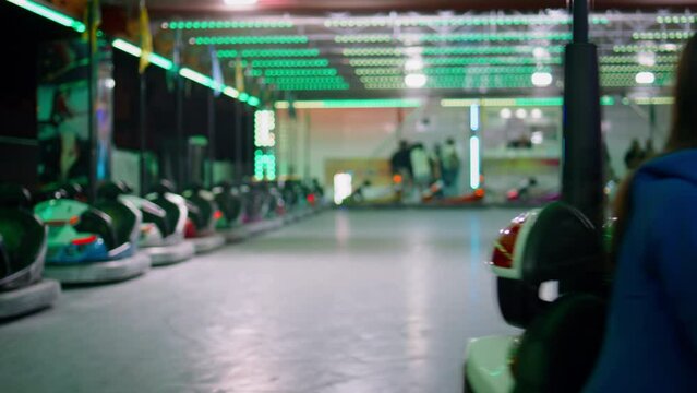 Joyful friends riding bumper car in luna amusement park. Smiling girls resting