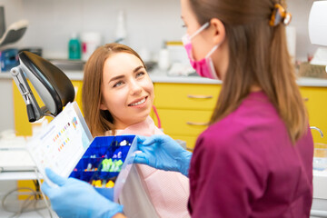 Young blond woman visits stomatologist clinic and listening to the doctor