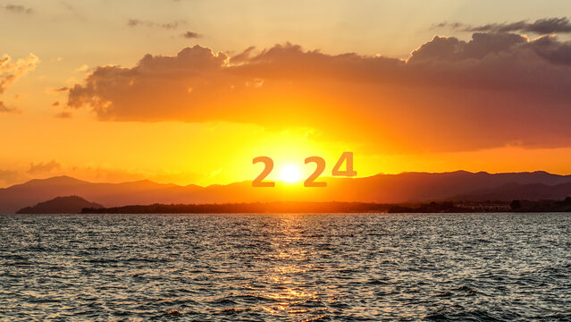 Happy New Year 2024 anniversary. Transition from 2023 to new year 2024 concept with text on sun rising sky. Photo image can be used as large display, print, website banner, social media post.