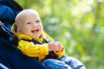 Baby boy in stroller in autumn park