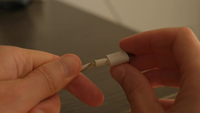 Broken cable from a smartphone close-up. Possibility of fire during use.