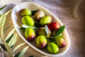 fresh green olives with leaves and olive oil