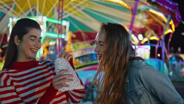 Joyful girls talking sharing secrets at luna amusement park. Happy best friends