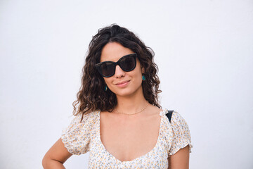Stylish young girl: 26 year old brown-haired beauty posing in front of a white wall.