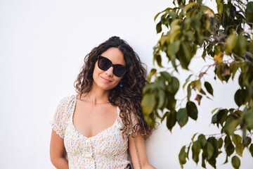 Stylish young girl: 26 year old brown-haired beauty posing in front of a white wall.