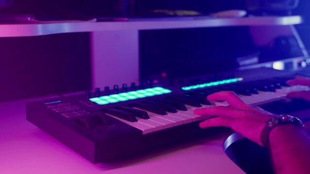composer man is playing keyboard in modern digital audio workstation, closeup view of hand