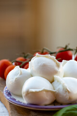 White balls of Italian soft cheese Mozzarella di Bufala Campana served with fresh green basil and red sicilian tomatoes