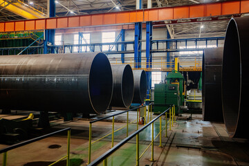Modern seam pipe factory production line. New manufactured pipes on roller conveyor