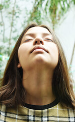 Mujer respirando aire puro cerrando sus ojos para disfrutar del ambiente.