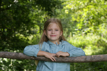 Candid headshot of adorable little girl in the forest, spending time in the nature, outdoors experience in the countryside	