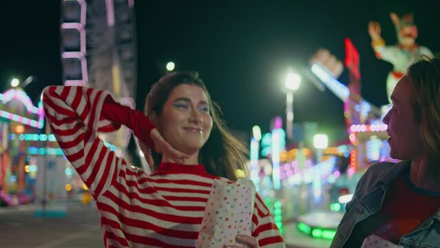 Happy friends eating popcorn walking funfair closeup. Joyful funny girls throw