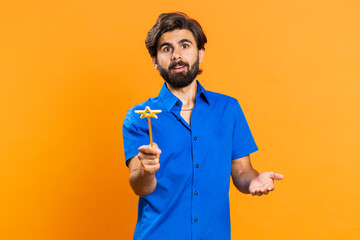 Magician witch middle eastern man gesturing with magic wand fairy stick, making wish come true,...