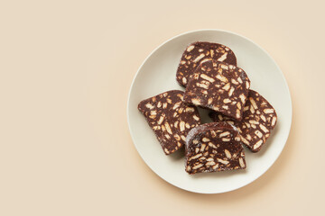 Traditional portuguese dessert Salame de Chocolate on beige background in minimal style. Restaurant bakery menu