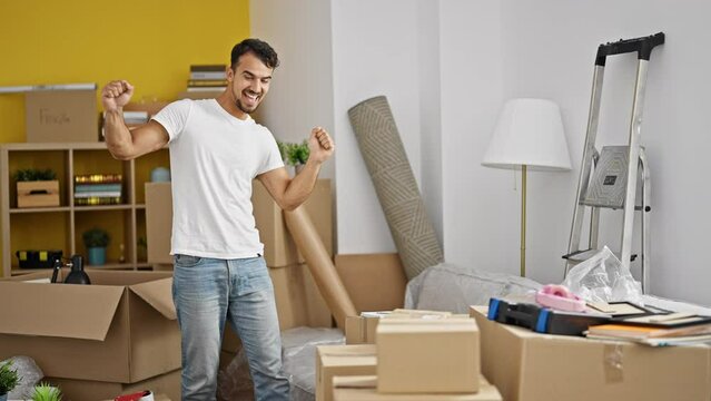 Young hispanic man smiling confident dancing at new home