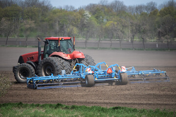 Fototapeta premium Farming Precision: Tractor's Careful Soil Cultivation