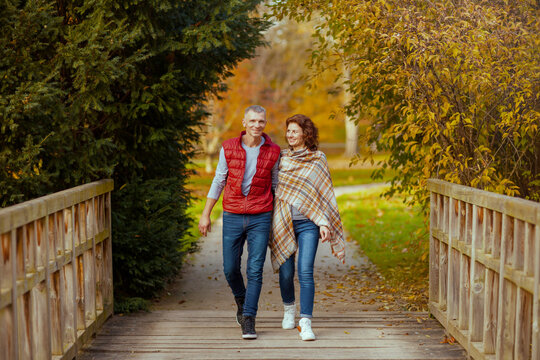 Full length portrait of smiling romantic couple in park walking