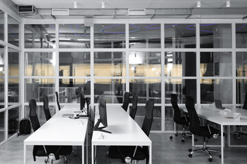 Stylish interior of open plan office. Workspace with computers, tables and chairs © New Africa